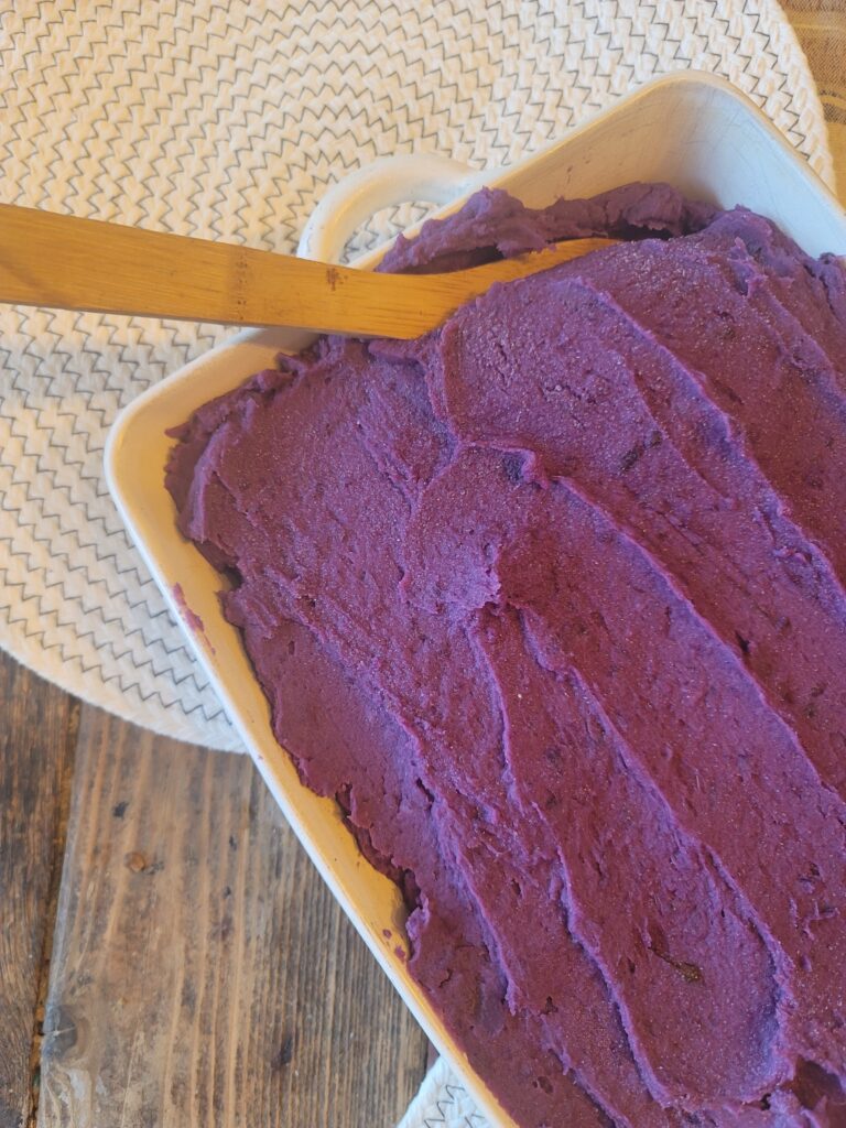 purple mashed potatoes spread out in serving dish