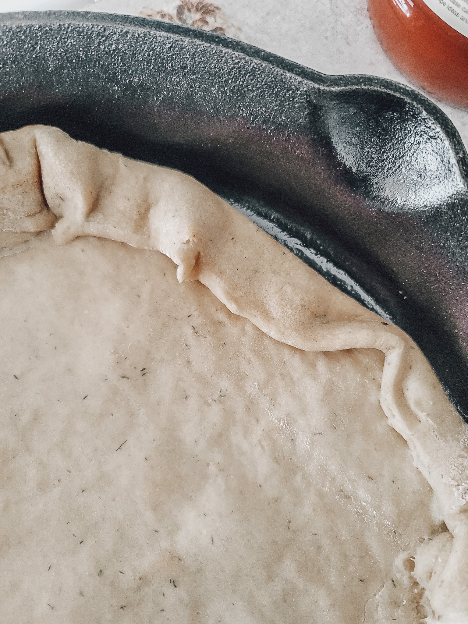 When the cast irons are ready, carefully remove them from the oven and drizzle them with oil. Place the dough inside and carefully fold over the corners to create a crust. Einkorn pizza dough