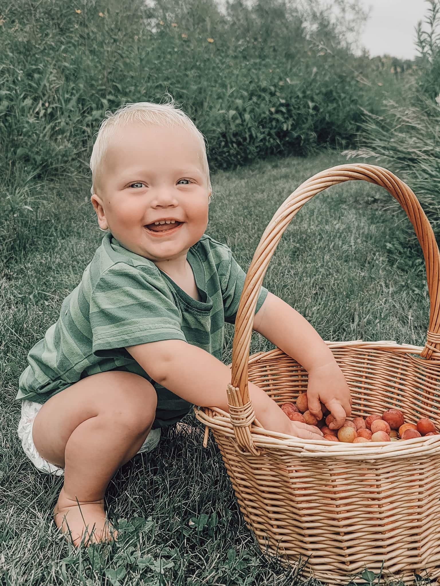 baby smiling with plums 