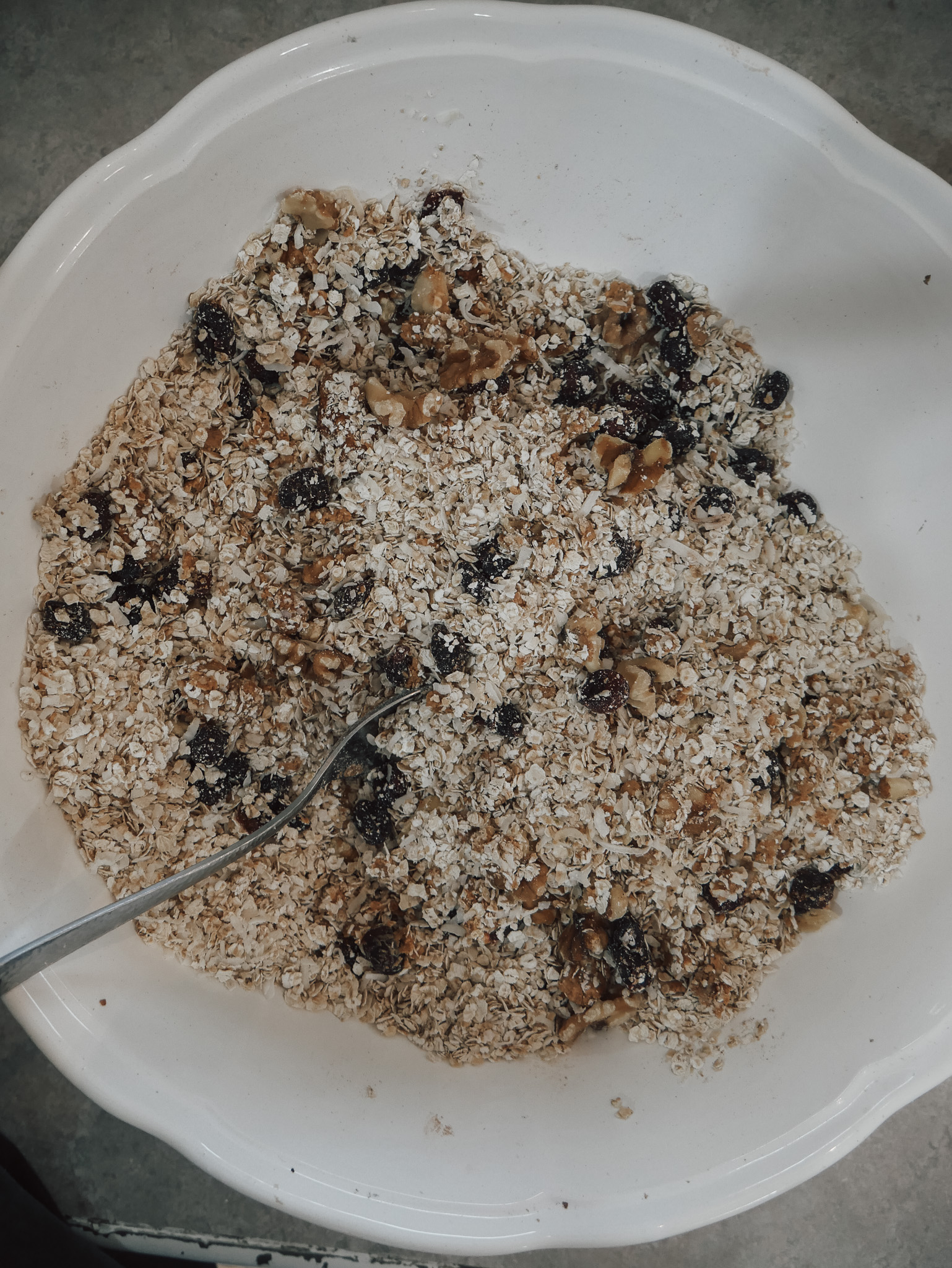 In a large mixing bowl, combine the rolled oats, chopped walnuts, unsweetened coconut flakes, craisins, cinnamon, and salt. Stir until the dry ingredients are evenly mixed. simple homemade granola recipe